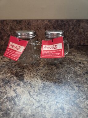 Coca-Cola Clear Glass Shaker Set with Red Logo Tags and Silver Lids